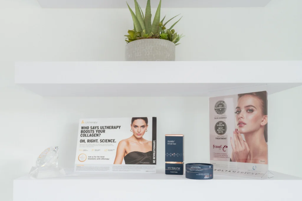 Ultherapy promotional display with skincare products and marketing materials on a clean white shelf.