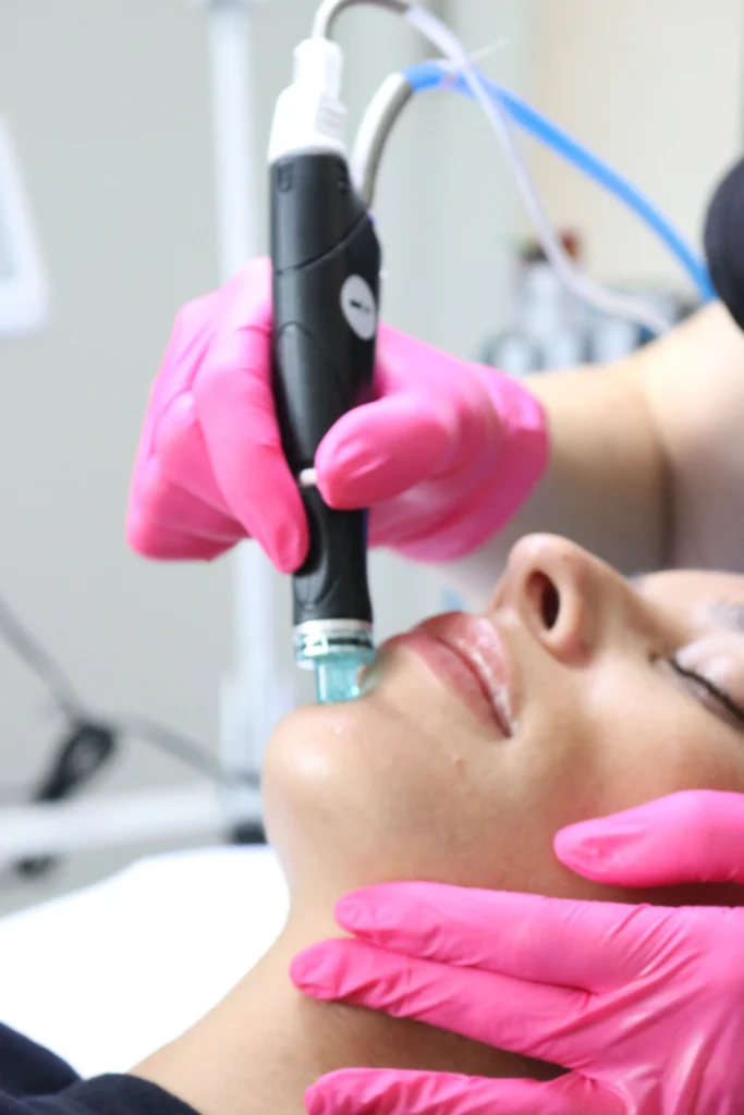 woman receiving hydrafacial treatment with cleansing tool